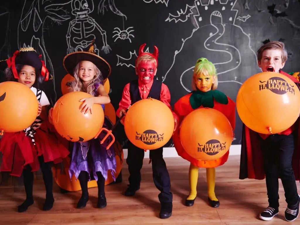 Friends swapping eco-friendly Halloween costumes at a costume swap party